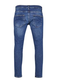 Siniset farkut, joissa on slim fit -muotoilu, kaksi takataskua ja vetoketjut nilkoissa. Tekstuuri on sileä ja hieman haalistunut.
