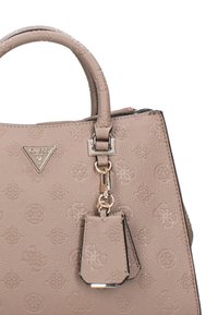 Borsa a tracolla beige con texture, caratterizzata da un motivo logo in rilievo, manici doppi e un tag removibile. Gli accenti includono una placca triangolare con logo e accessori in metallo.
