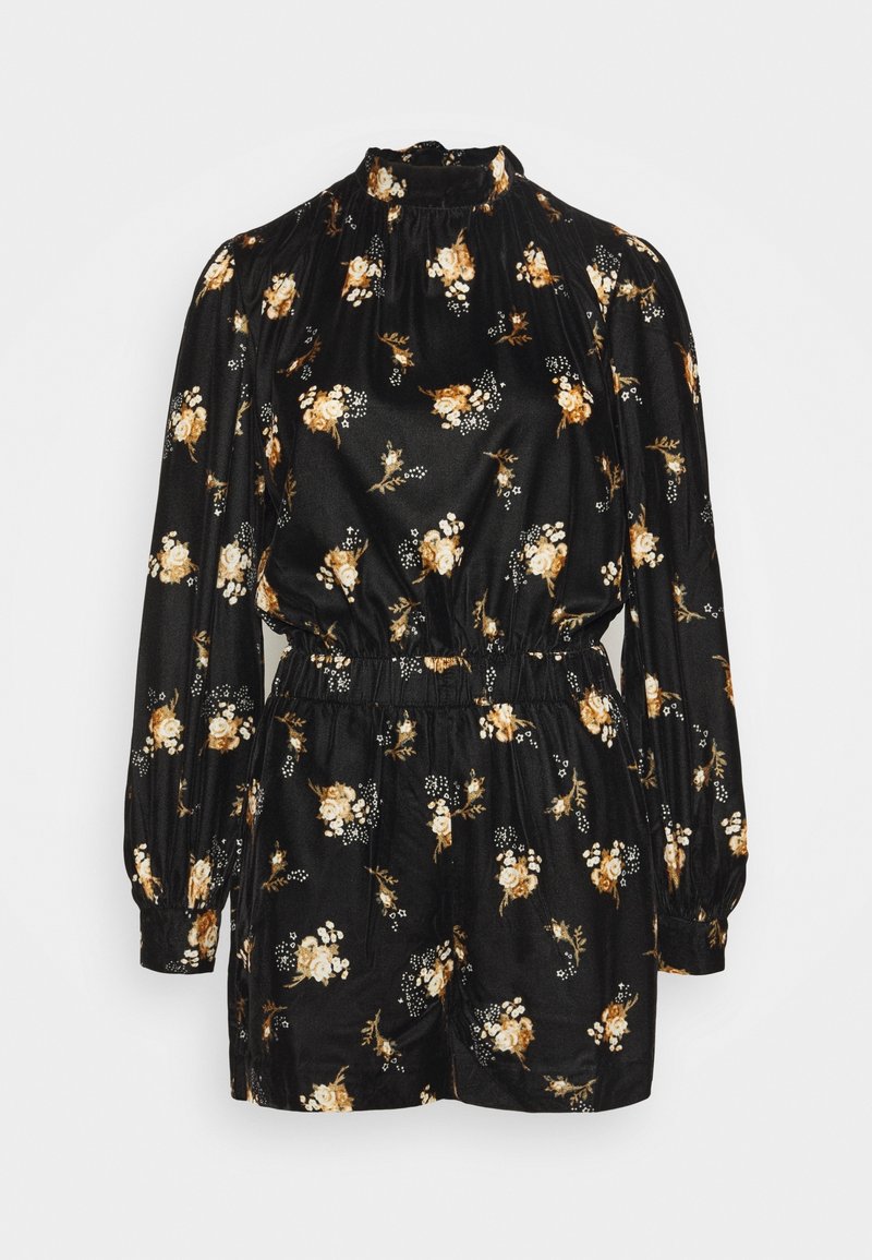 Combinaison noire à manches longues, col montant, taille élastique et motif floral dans des tons beige, blanc et marron.