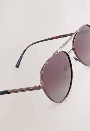 Kovové pilotné slnečné okuliare s prechodnými sivými šošovkami, tenkými ružovo-zlatými obrúčkami a viacfarebnými vzorovanými nožičkami.