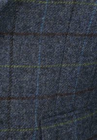 Wollen stof in marineblauw met een geruit patroon dat blauwe, groene en bruine accenten bevat; gestructureerde afwerking met zichtbare vezels en stiksels.