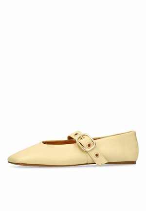 Chaussure plate Mary Jane en cuir beige avec bout pointu et grande boucle de sangle sur le dessus du pied.