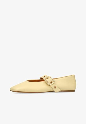 Beige flat leather Mary Jane shoe with pointed toe and large strap buckle across the instep.