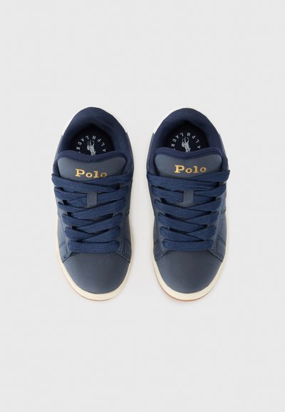 Mörkblå sneakers med texturerat tyg, platta snören och vit sula. "Polo"-logotyp i guld på sidan och en logotyp på innersulan.
