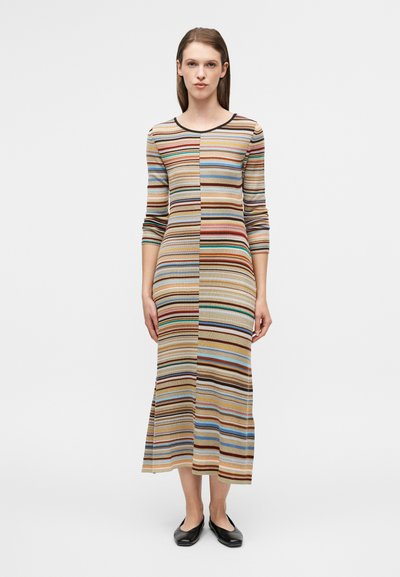 Ριγέ πλεκτό φόρεμα με μακριά μανίκια, στρογγυλή λαιμόκοψη και μήκος μέχρι τη μέση της γάμπας. Τα χρώματα περιλαμβάνουν μπεζ, καφέ, μπλε και πορτοκαλί σε διάφορα πλάτη.