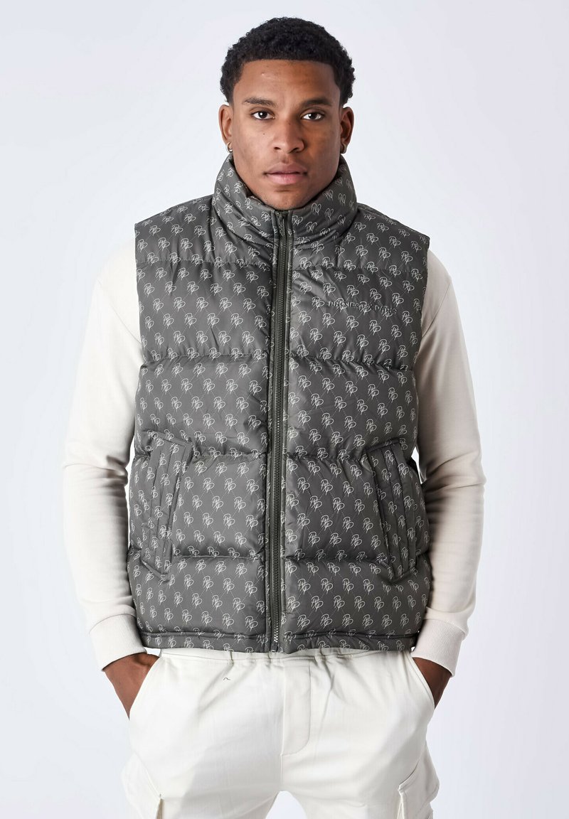 Gilet matelassé gris avec col montant, arborant un motif logo répété, fermeture éclair sur le devant et deux poches latérales. Tissu texturé de poids moyen.