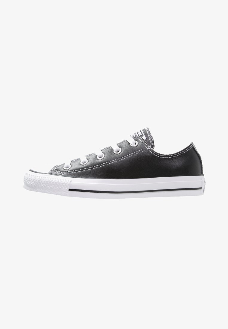 Fekete alacsony szárú sneaker, gumitalppal, fehér fűzőkkel és fehér talppal. Bőrből készült felsőrész kontrasztos varrással és fekete csíkos díszítéssel.