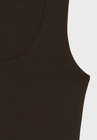 Vêtement sans manches marron foncé avec un col arrondi, présenté sur un fond clair uni, mettant en valeur la texture et la forme du tissu.
