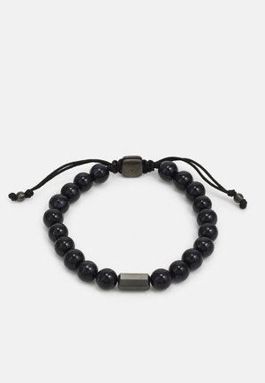 Schwarzes Perlenarmband mit glatten Kugeln, die einen subtilen Glanz haben, und rechteckigen Metallelementen, dazwischen eingesprenkelt, verstellbarer schwarzer Kordel.