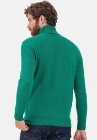 Pull vert ajusté avec un col haut, des manches longues et des poignets et un ourlet côtelés. Texture douce, présenté de dos sur un fond blanc.