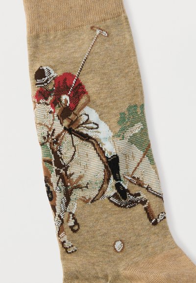 Κάλτσα με πλεκτό σχέδιο παίκτη πόλο με κόκκινο πουκάμισο που ιππεύει ένα άλογο και κουνάει ένα ρόπαλο προς μια μπάλα.