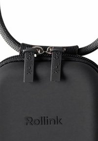 Schwarzer Rucksack mit einem schlanken Design, weichem Material, strukturiertem Schultergurt und Metallreißverschlüssen mit eingravierten "Rollink"-Tags.