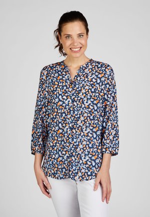 Floral button-up shirt in navy with white, orange, and light blue patterns. Features a collar and three-quarter sleeves. Soft fabric texture.