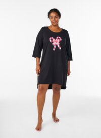 Svart nattlinne av mjukt tyg med trekvartslånga ärmar och en framdesign med rosa och vita polkagrisar med rosett.