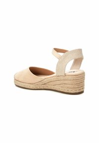 Espadrille de ante beige con un tacón de yute trenzado, que cuenta con una correa cruzada ajustable hecha de tejido texturizado. Forro interior suave.