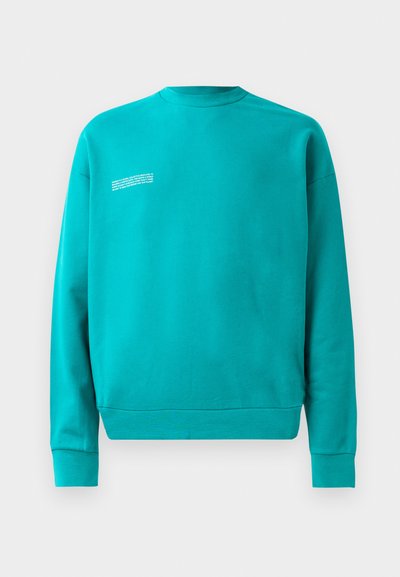 Tyrkysový sweatshirt, zmes bavlny, okrúhly výstrih, dlhé rukávy. Textový detail na hornej ľavej strane. Rybárové manžety a spodný lem. Hladká textura, ležérny dizajn.