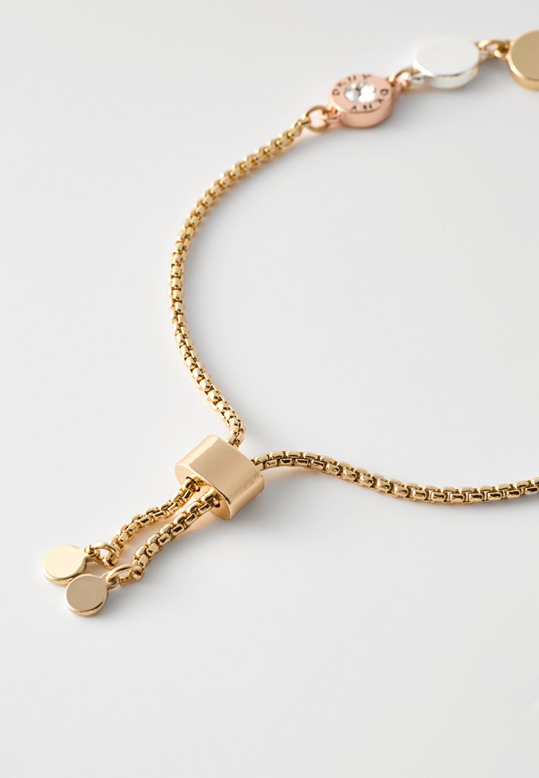 Goldkette mit einem schlichten, rechteckigen Verschluss und runden metallischen Akzenten in Roségold, Silber und Weiß.