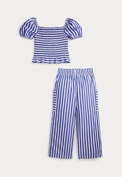 Sinine ja valge triibuline kärbitud pintsak mantliprindis, millel on õhupallivarrukad, ning sobivad kõrge vöökohaga laia säärega püksid küljetaskutega.