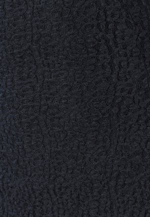 Melns teksturēts audums ar smalku, paceltu rakstu. Materiāls izskatās mīksts ar viegli caurspīdīgu īpašību, piemērots dažādiem dizainiem.