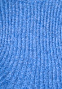 Zbliżenie niebieskiej dzianiny prążkowanej, ukazującej pionowy, teksturowany wzór oraz miękkie włókna.