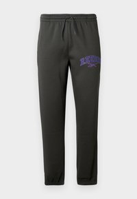Černé joggingové kalhoty vyrobené z měkké tkaniny, s elastickým pasem na šňůrku a fialovým logem "Reebok" na levém stehně.