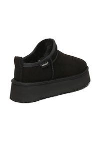 Schwarzer Slip-On-Schuh mit dicker, strukturierter Sohle, weichem Innenfutter und „EVERAU“-Etikett an der Seite für den Freizeit- oder Innenbereich.