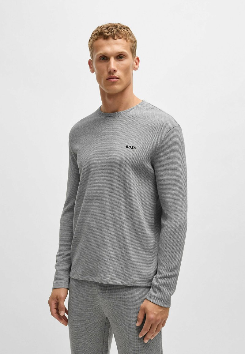 Grijze langemouwen T-shirt in een gestructureerde stof, met een ronde halslijn en een klein zwart "BOSS" logo op de borst.