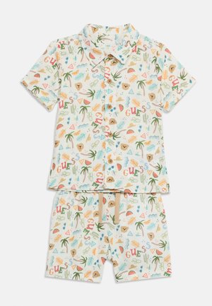 Ensemble chemise à manches courtes boutonnée et short pour enfant avec imprimés tropicaux multicolores et visages d’ours sur fond blanc.