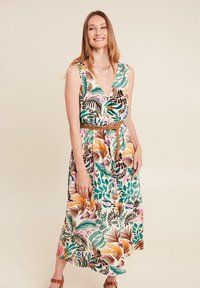 Ärmelloses Maxikleid mit Blumenmuster aus weichem Stoff; verfügt über einen tiefen V-Ausschnitt und einen braunen Gürtel in der Taille. Die Farben umfassen Grün, Pink und Orange.