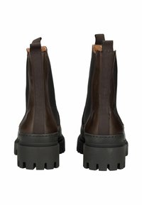 Hnědé kožené kotníkové boty s elastickými bočními panely, texturovanými černými gumovými podrážkami a poutky na zadní straně pro snadné obouvání.