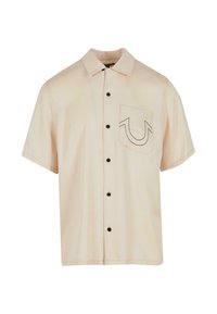 Camisa de manga corta de tejido beige claro, con cierre de botones en la parte delantera, botones negros y un bolsillo en el pecho con un diseño de contorno en contraste.