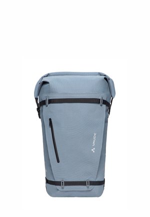 Lichtblauwe rugzak met oprolbare bovenkant, voorvak met rits, zwarte banden en VAUDE-logo op het voorpaneel.