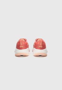 Rosen- und pfirsichfarbene Laufschuhe mit einem strukturierten Mesh-Obermaterial, ausgeprägten Zuglaschen an der Rückseite und flexiblen Gummisohlen. Mit gelben Stichen akzentuiert.