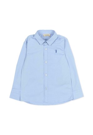 Chemise bleu clair à manches longues avec boutons, col et petit logo brodé sur la poitrine gauche, posée à plat sur fond blanc.