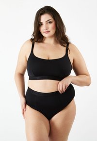 Svart bh och högmidjade trosor, tillverkade av mjukt tyg med tunna band och en logoband, har en slät textur och en åtsittande passform.