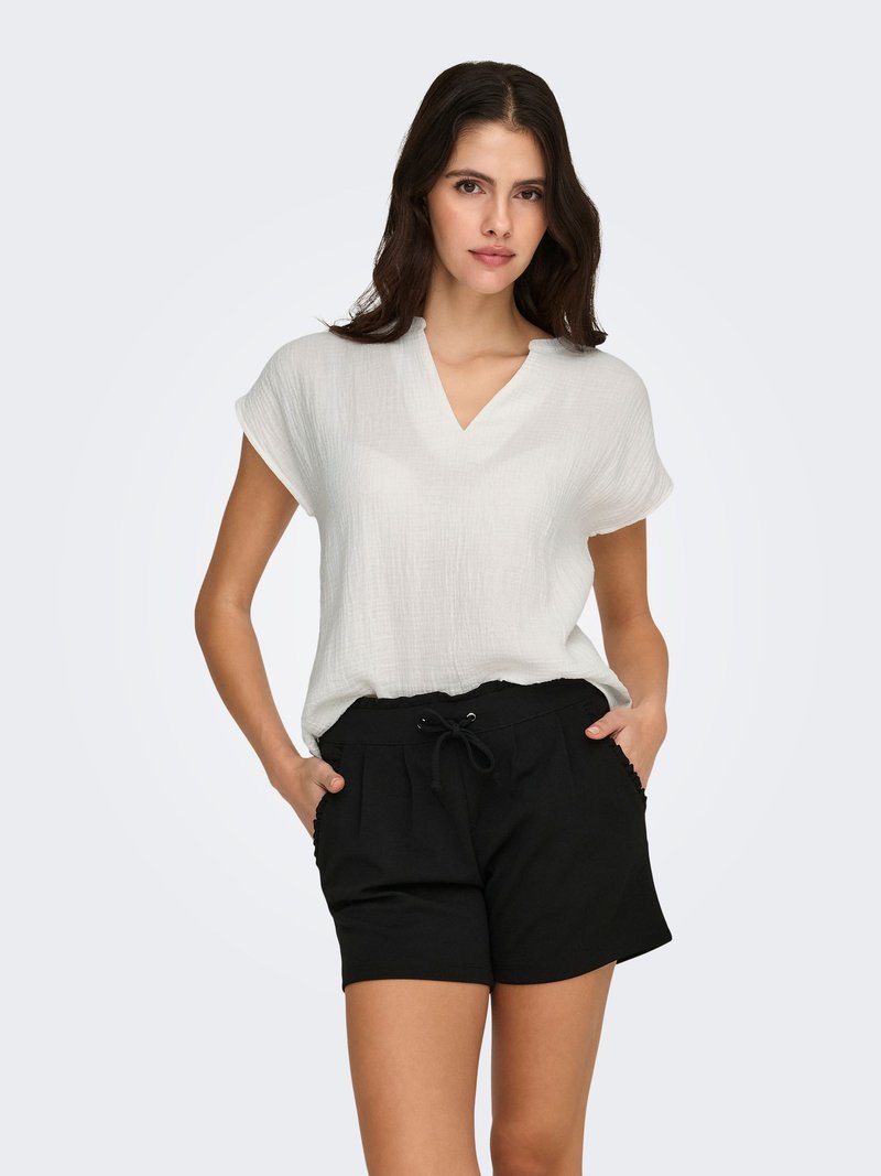 Witte blouse met textuur, V-hals en korte mouwen, gecombineerd met zwarte shorts met een elastische tailleband en zijzakken.