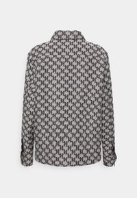 Skjorta med ett geometriskt mönster i marinblått på en ljusgrå bakgrund, med krage och knäppta manschetter. Materialet verkar vara texturerat.