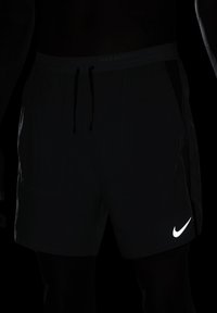 Črne Nike tekaške kratke hlače z elastičnim pasom, vrvico in odsevnim logotipom na spodnjem desnem delu. Lahka tkanina, zasnovana za udobje.