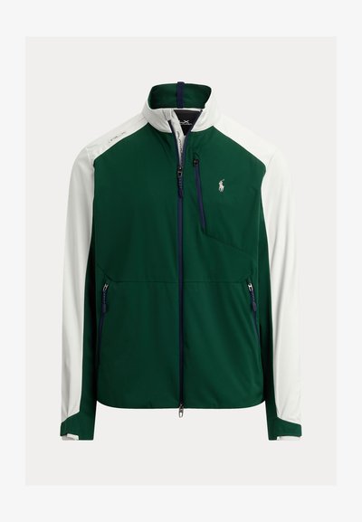 Veste softshell zippée verte et blanche avec col montant, poches poitrine et latérales zippées, et logo Polo Ralph Lauren sur le côté gauche de la poitrine.