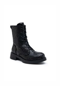 Bottine noire à lacets avec un motif serpentin texturé et brillant, et un petit talon carré.