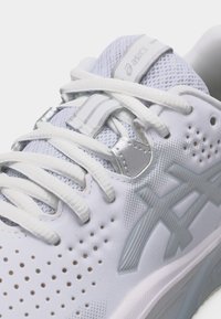 Άσπρο αθλητικό παπούτσι Asics με επάνω μέρος από πλέγμα, λευκά κορδόνια, διάτρητο πλάι και γκρι λογότυπο της μάρκας στο πλάι.