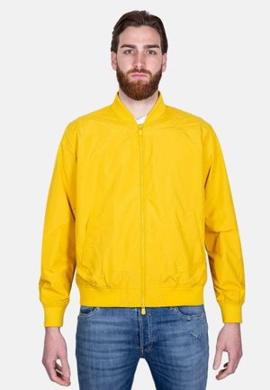 Giacca bomber gialla con chiusura a zip, polsini a costine e vita elastica. Realizzata in materiale leggero con una texture liscia e lucida.