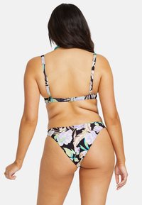 Bikini-set med svart bas, med ett blommönster i pastellfärger. Justerbara axelband och en spänne stängning på ryggen.