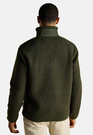 Green fleece jacket with textured surface, high collar, and embossed "JOULES" branding on the collar. Designed with side pockets.