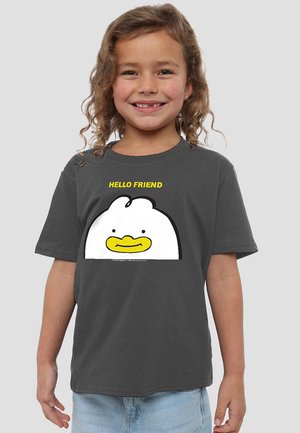 Young child with curly hair wearing a dark gray t-shirt depicting a cartoon white bird with a yellow beak and text "HELLO FRIEND".