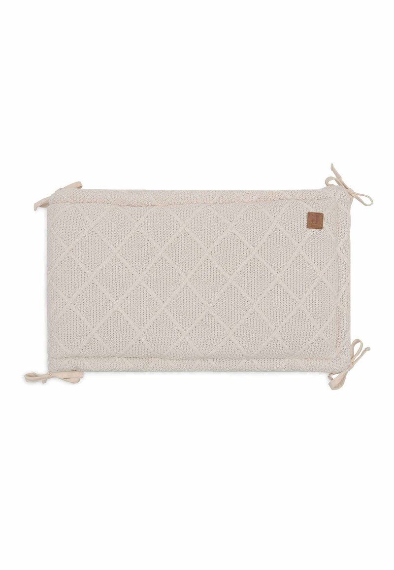 Rechthoekig kussen van lichtbeige gebreide stof, met een ruitpatroon en gestrikte uiteinden. Inclusief een klein leren label aan de zijkant.