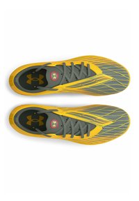 Scarpe da ginnastica gialle e grigie con una tomaia texturizzata, design elegante e dettagli a strisce. Presentano un logo sulla linguetta e una chiusura a lacci standard.