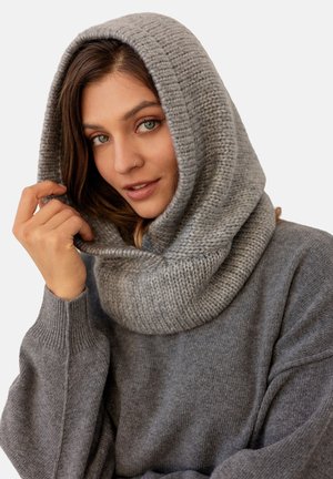 Szary dzianinowy golf z teksturowanym wzorem, wykonany z miękkiego materiału i luźnym krojem. Element ten ma ściągacze i przytulny, oversize'owy fason.