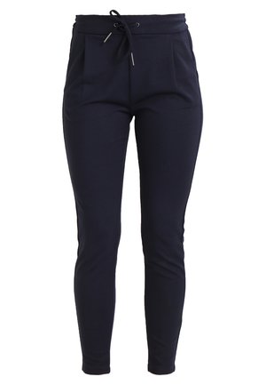 Námornícky modré elastické joggers s pásom na šnúrku, so zúženým strihom a prednými záhybmi pre dodatočný detail. Mäkčená textúra látky.