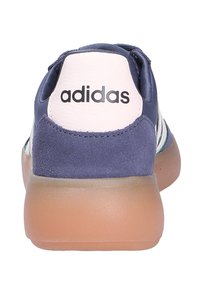 Rear view of navy blue Adidas sneaker with white heel tab and gum sole.